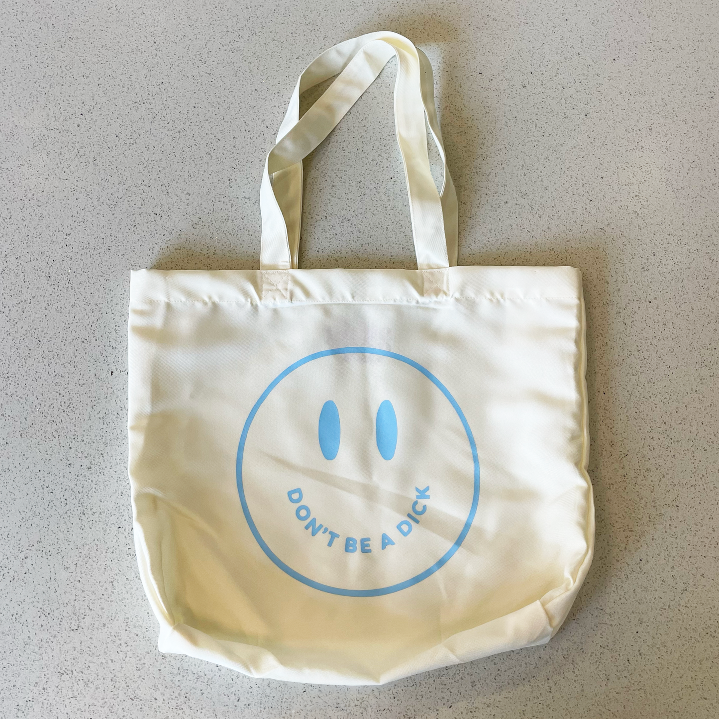 tote bag with blue smiley face saying don't be a dick