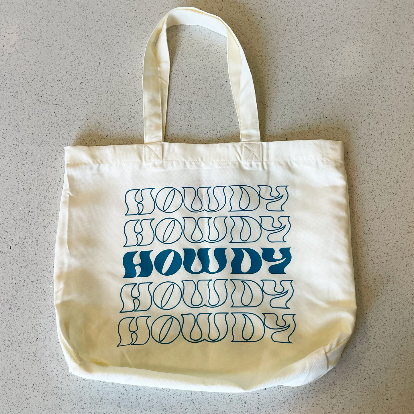 tote bag that says howdy in teal