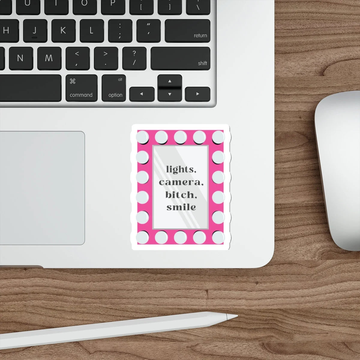 pink vanity mirror that has Taylor Swift lyrics "lights, camera, bitch, smile" sticker on laptop