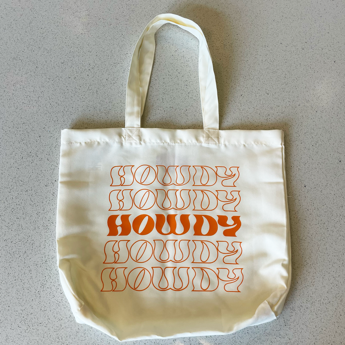 tote bag that says howdy in orange