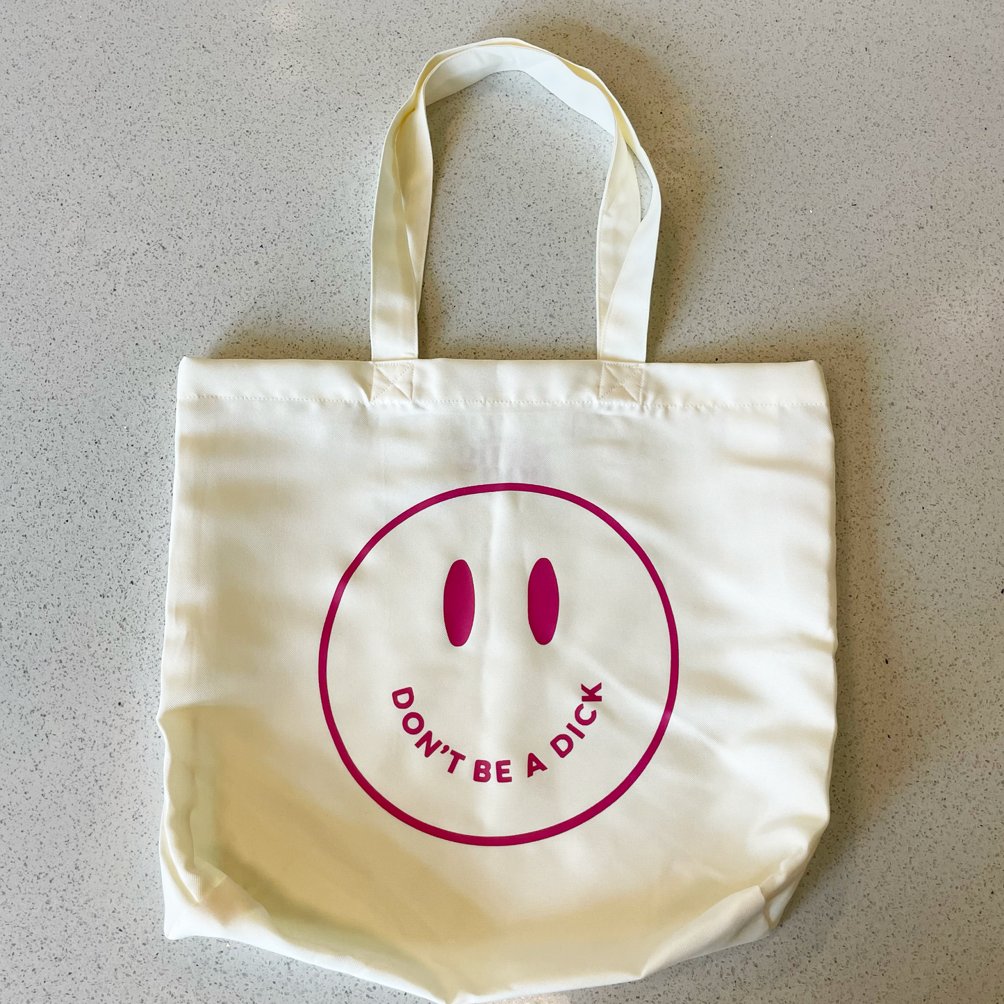 tote bag with mauve smiley face saying don't be a dick