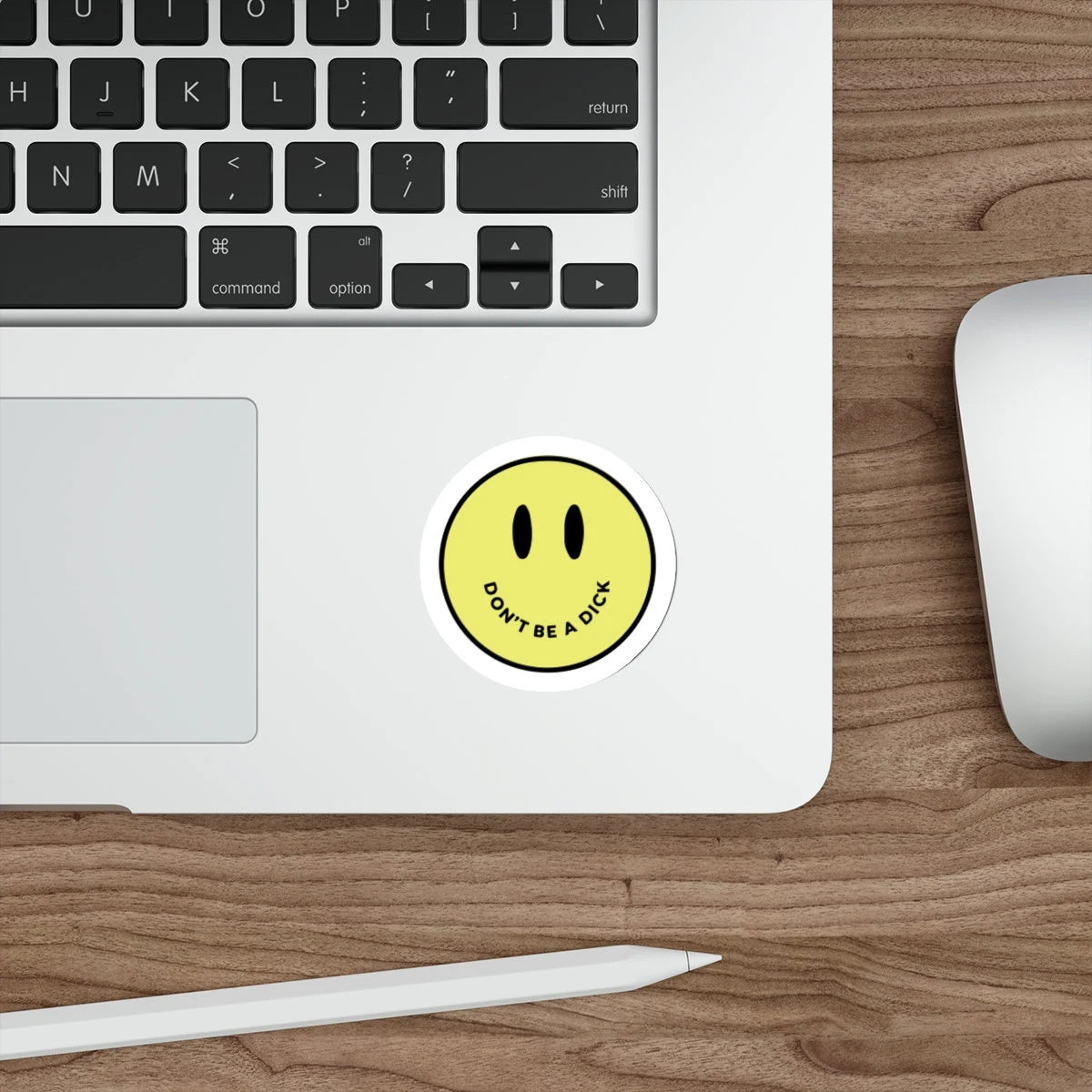 Smiley face sticker saying don't be a dick on a laptop
