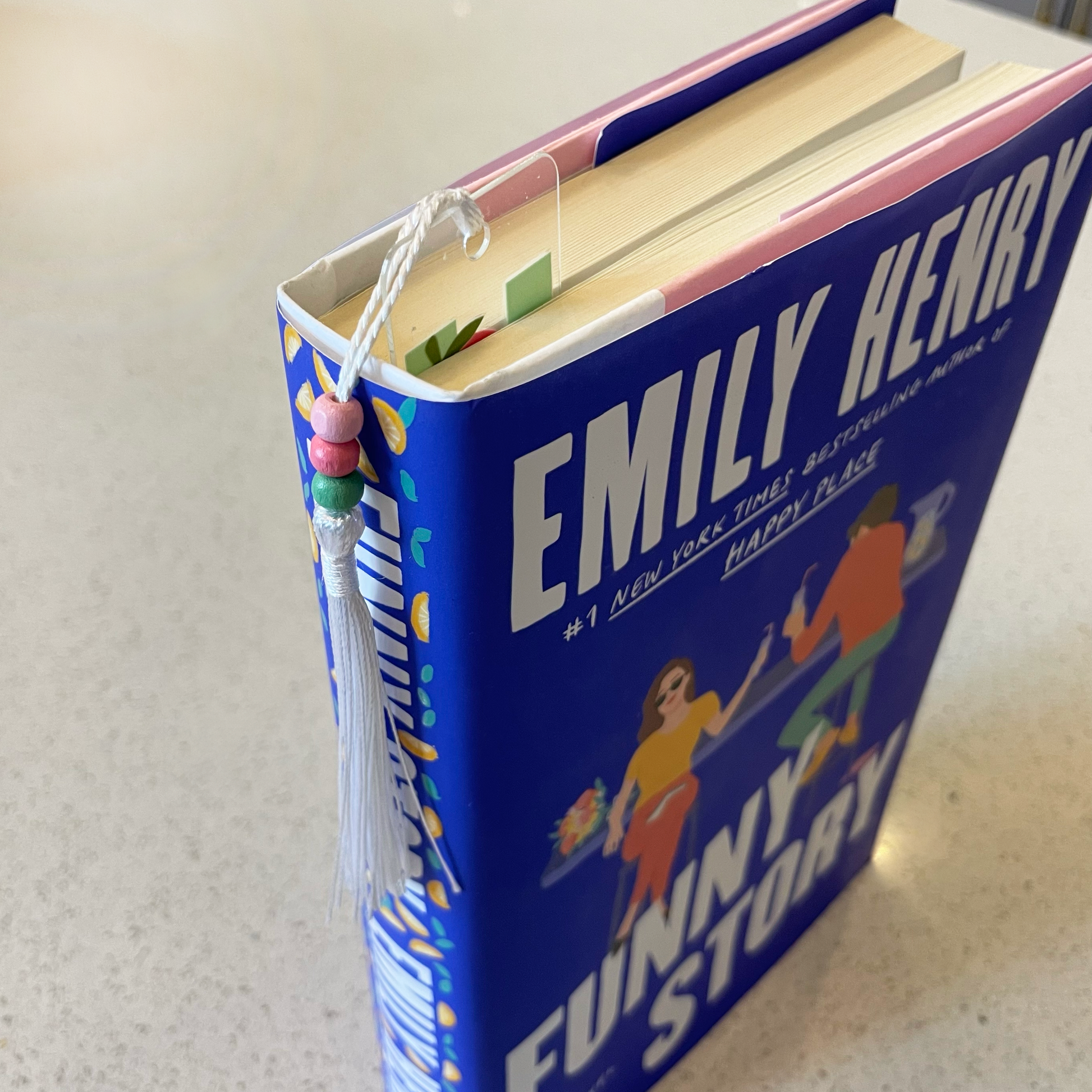 an acrylic bookmark in the book Funny Story by Emily Henry
