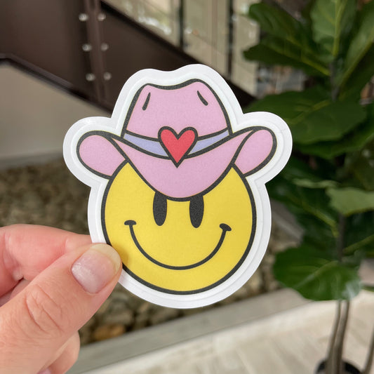 hand holding yee haw smiley face sticker